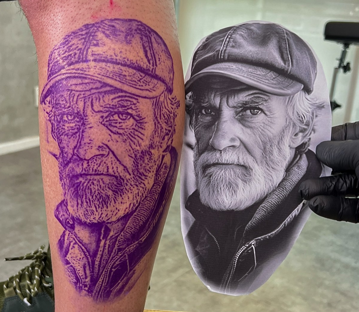 Decalque na perna ao lado da foto de referência impressa, no início da tatuagem do curso